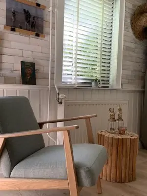 a room with a chair and a table and a window at Appartement 't Souterrain in Zandvoort
