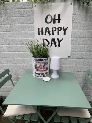 a sign that says oil happy day sitting on a table at Appartement 't Souterrain in Zandvoort
