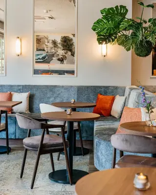 a restaurant with tables and a couch at Boutique Hotel Malie House in Utrecht