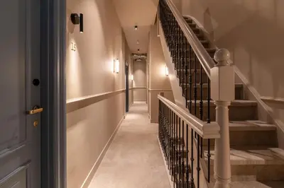 a hallway with a staircase with white railings at Boutique Hotel Malie House in Utrecht