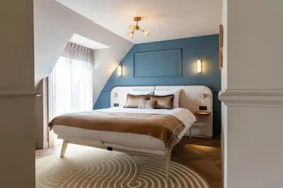a bedroom with a bed with a blue wall at Boutique Hotel Malie House in Utrecht