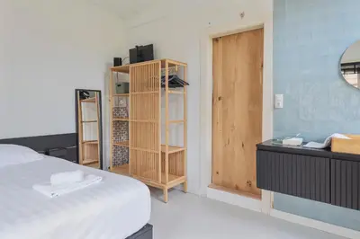 a bedroom with a bed and a wooden cabinet at Second Paradise for 2 adults and 2 children in Zandvoort