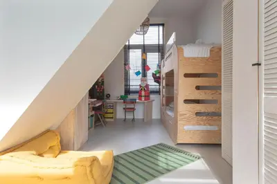 a living room with a yellow couch and a bedroom at Second Paradise for 2 adults and 2 children in Zandvoort