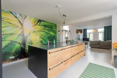 a kitchen with a large painting on the wall at Second Paradise for 2 adults and 2 children in Zandvoort