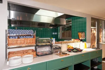 a kitchen with green tiled walls and a counter at Hotel Nicolaas Witsen in Amsterdam