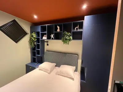 a bedroom with a white bed and shelves at Hotel Nicolaas Witsen in Amsterdam