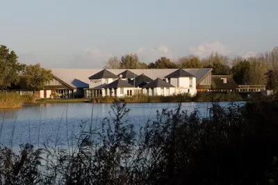 a row of houses next to a body of water at Fletcher Hotel - Resort Spaarnwoude in Velsen-Zuid
