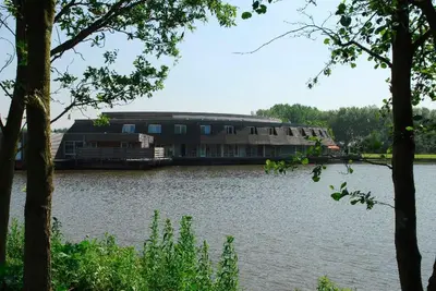 a large building on the side of a lake at Fletcher Hotel - Resort Spaarnwoude in Velsen-Zuid