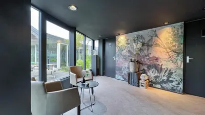a living room with a large painting on the wall at Fletcher Hotel - Resort Spaarnwoude in Velsen-Zuid
