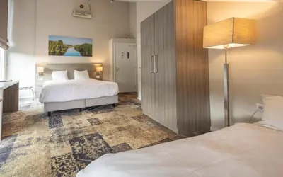 a hotel room with two beds and a lamp at Fletcher Hotel - Resort Spaarnwoude in Velsen-Zuid