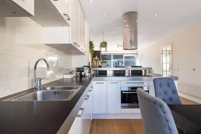 a kitchen with white cabinets and a sink at Luxury Apartment near Utrecht & Amsterdam in Breukelen