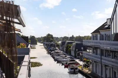 a river with boats parked next to buildings at Luxury Apartment near Utrecht & Amsterdam in Breukelen
