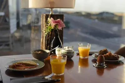 a table with plates of food and two glasses of orange juice at Hotel Noordzee in Katwijk