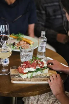 a table with a plate of food and glasses of wine at Hotel Noordzee in Katwijk