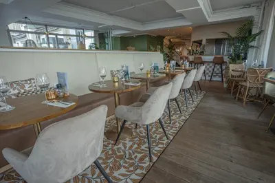 a row of tables and chairs in a restaurant at Hotel Noordzee in Katwijk