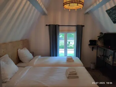 two beds in a room with a window at 't Wapen van Middelie in Middelie