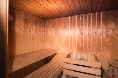 a wooden sauna with a wooden bench in it at Golden Tulip Ampt van Nijkerk in Nijkerk