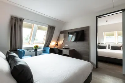 a hotel room with a bed and a mirror at Golden Tulip Ampt van Nijkerk in Nijkerk