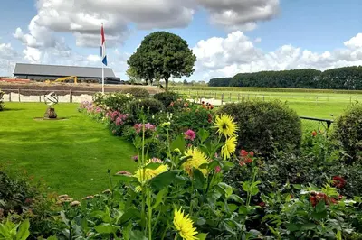 a garden of flowers with a building in the background at De Mast bij Fort Vechten on the countryside & close to Utrecht in Bunnik