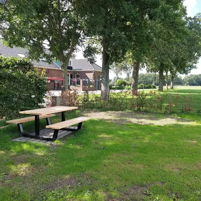 a wooden picnic table in a field with trees at De Mast bij Fort Vechten on the countryside & close to Utrecht in Bunnik