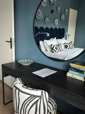 a mirror above a table with a bed in a room at Near Amsterdam and airport, 90m2, privacy! in Hoofddorp