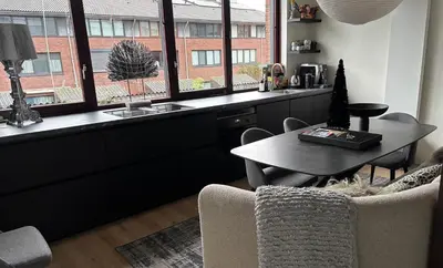 a living room with a table and a window at Near Amsterdam and airport, 90m2, privacy! in Hoofddorp