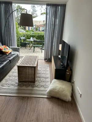 a living room with a couch and a tv at Noordwijk BB228 in Noordwijk