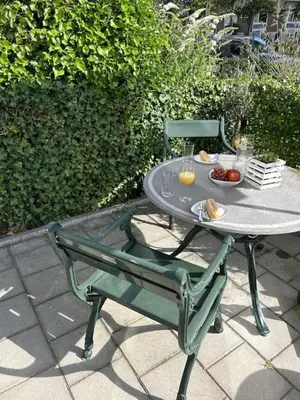 a table and a chair with a bowl of fruit on it at Noordwijk BB228 in Noordwijk