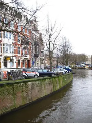 a group of cars parked next to a river at Hotel Titus City Centre in Amsterdam