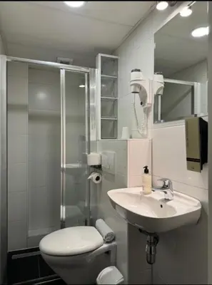 a bathroom with a toilet and a sink and a shower at Hotel Titus City Centre in Amsterdam