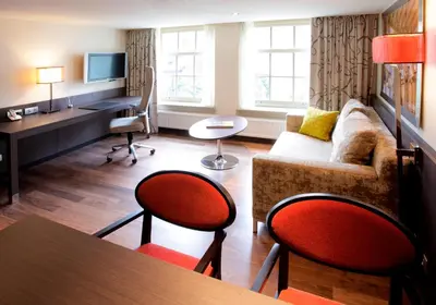 a living room with a couch and a desk at Krasnapolsky Apartments in Amsterdam