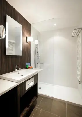 a bathroom with a sink and a shower at Krasnapolsky Apartments in Amsterdam