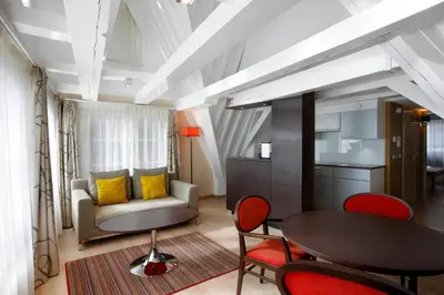 a living room with a table and chairs and a couch at Krasnapolsky Apartments in Amsterdam