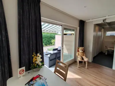 a living room with a teddy bear sitting on a chair at Aangepast vakantiehuis Sandra mindervaliden in Limmen
