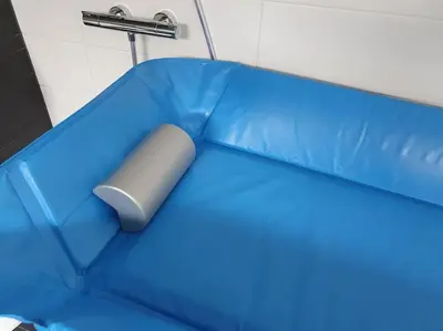 a blue couch with a gray object on it at Aangepast vakantiehuis Sandra mindervaliden in Limmen