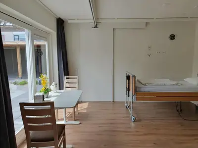 a room with a bed and a table and chairs at Aangepast vakantiehuis Sandra mindervaliden in Limmen