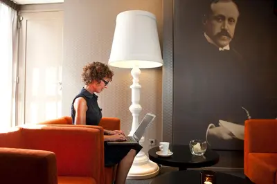 a woman sitting in a chair with a laptop at Hotel Ernst Sillem Hoeve in Den Dolder