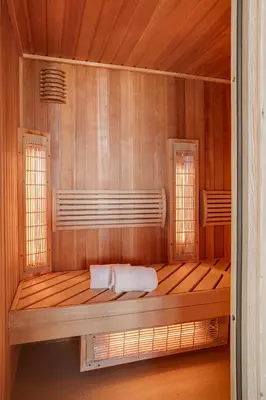 a wooden room with a bed with two windows at Hotel Ernst Sillem Hoeve in Den Dolder