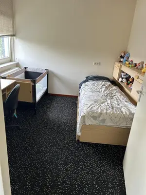 a small bedroom with a bed and a desk and a drawer at Cairo in Almere