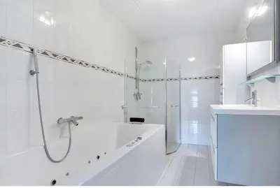 a white bathroom with a tub and a shower at Cairo in Almere