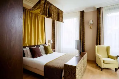 a hotel room with a bed and a chair at Grand Hotel Karel V in Utrecht