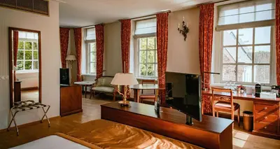 a living room with a flat screen tv and a couch at Grand Hotel Karel V in Utrecht
