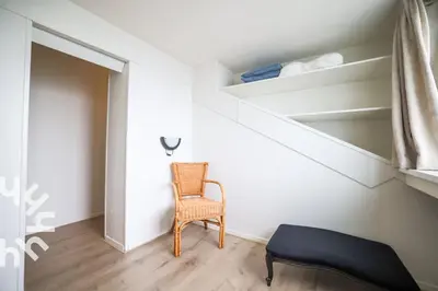 a room with a chair and a stair case at sunshine in Schoorl