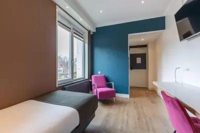 a hotel room with a bed and a pink chair at Amrâth Berghotel Amersfoort in Amersfoort