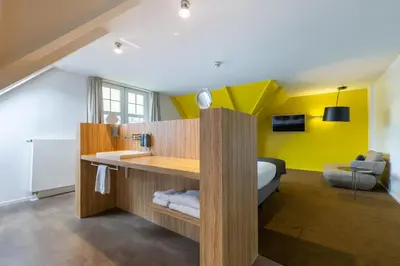 a bathroom with a sink and a bed in a room at Amrâth Berghotel Amersfoort in Amersfoort