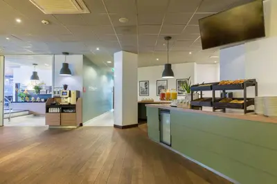 a lobby of a store with a counter and a kitchen at Leonardo Hotel Utrecht City Center in Utrecht