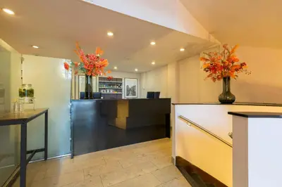 a lobby with two vases of flowers on a counter at Leonardo Hotel Utrecht City Center in Utrecht