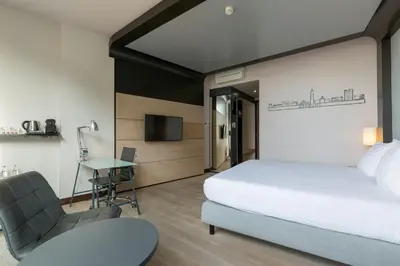 a bedroom with a bed and a desk and a chair at Leonardo Hotel Utrecht City Center in Utrecht