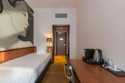 a hotel room with a bed and a desk with a coffee maker at Leonardo Hotel Utrecht City Center in Utrecht