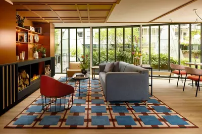a living room with a couch and chairs on a rug at Avani Museum Quarter Amsterdam Hotel in Amsterdam